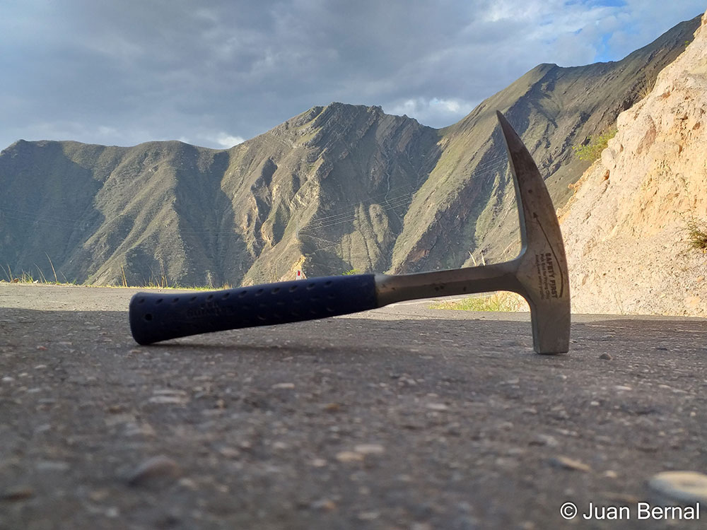 Honorable mention photo by Juan Bernal: Close-up of a geologist hammer with mountains in the background
